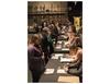 Attendees line up and shake hands with employers at the job fair